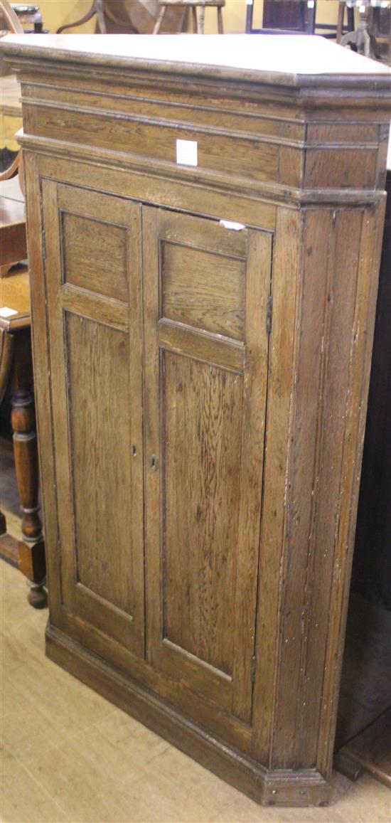 Early 19th century panelled oak two door corner cupboard